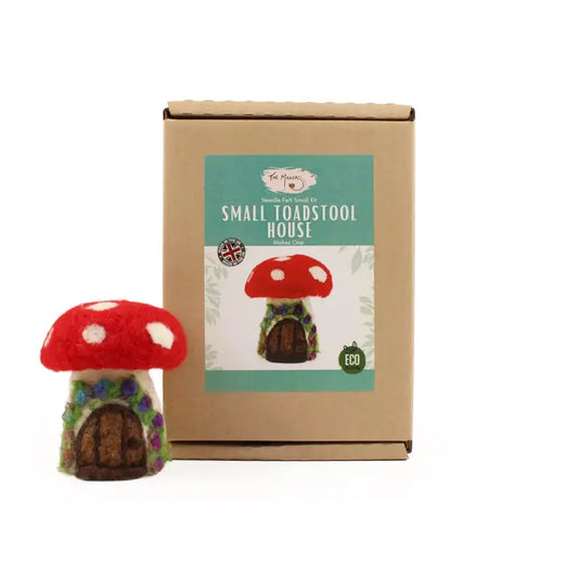 A needle felting kit package labeled 'Small Toadstool House' with a completed red and green toadstool house next to it, indicating the product inside the box.