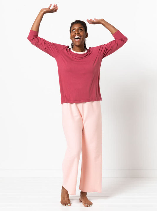 Woman wearing a custom pink top and light pink pants against a white background