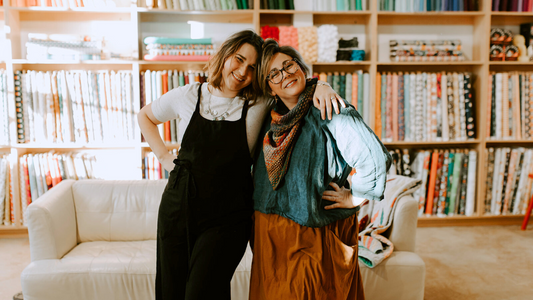 Two women, one wearing a linen shirt and the other wearing a linen dress.